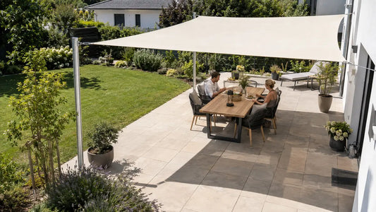 Großes Sonnensegel beschattet einen kompletten Essplatz auf einer sonnigen Gartenterrasse