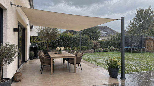 Wasserdichtes Sonnensegel schützt eine trockene Terrasse während eines leichten Hagelschauers
